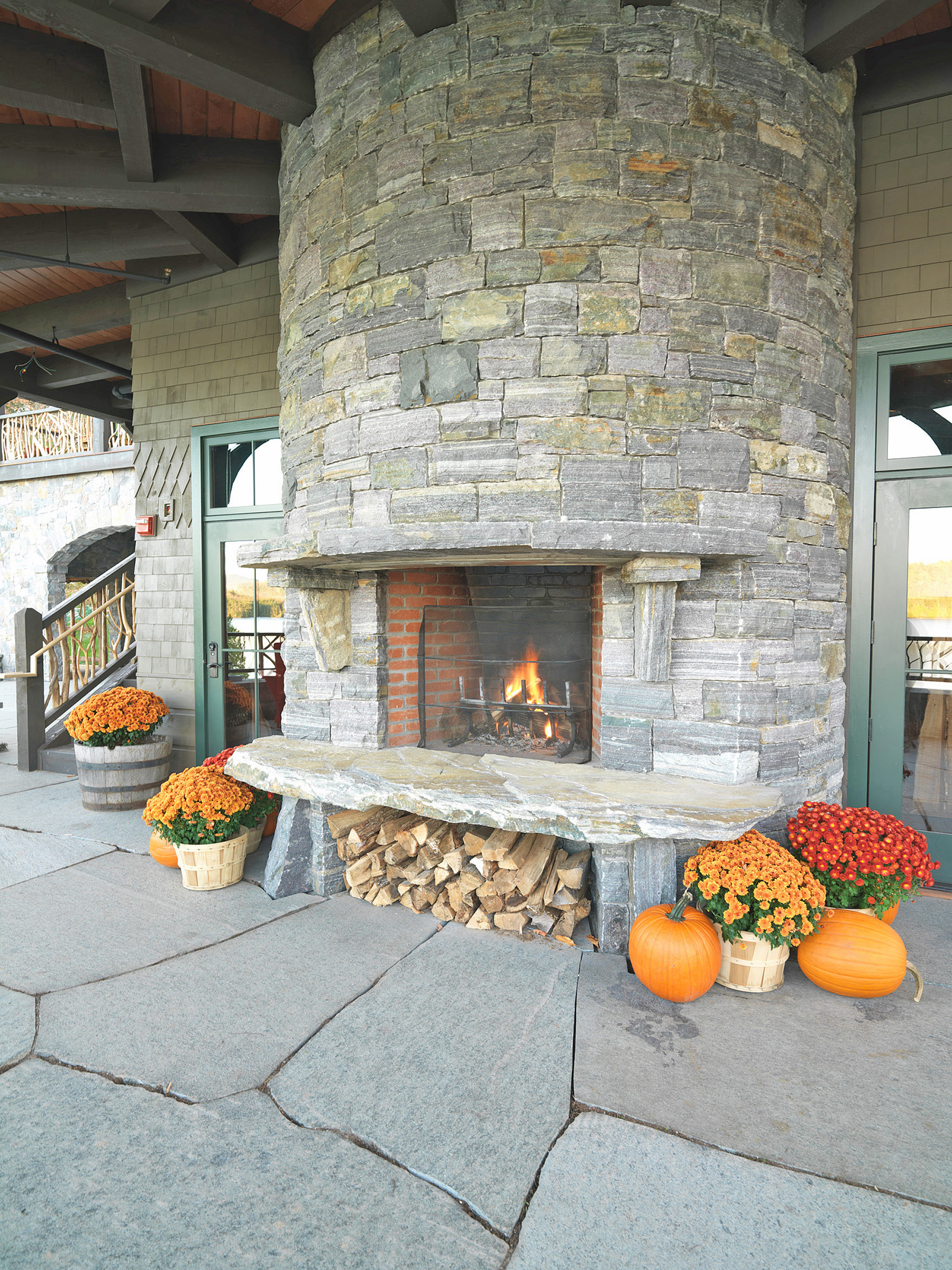 stone fireplace with pumpkins and flowers