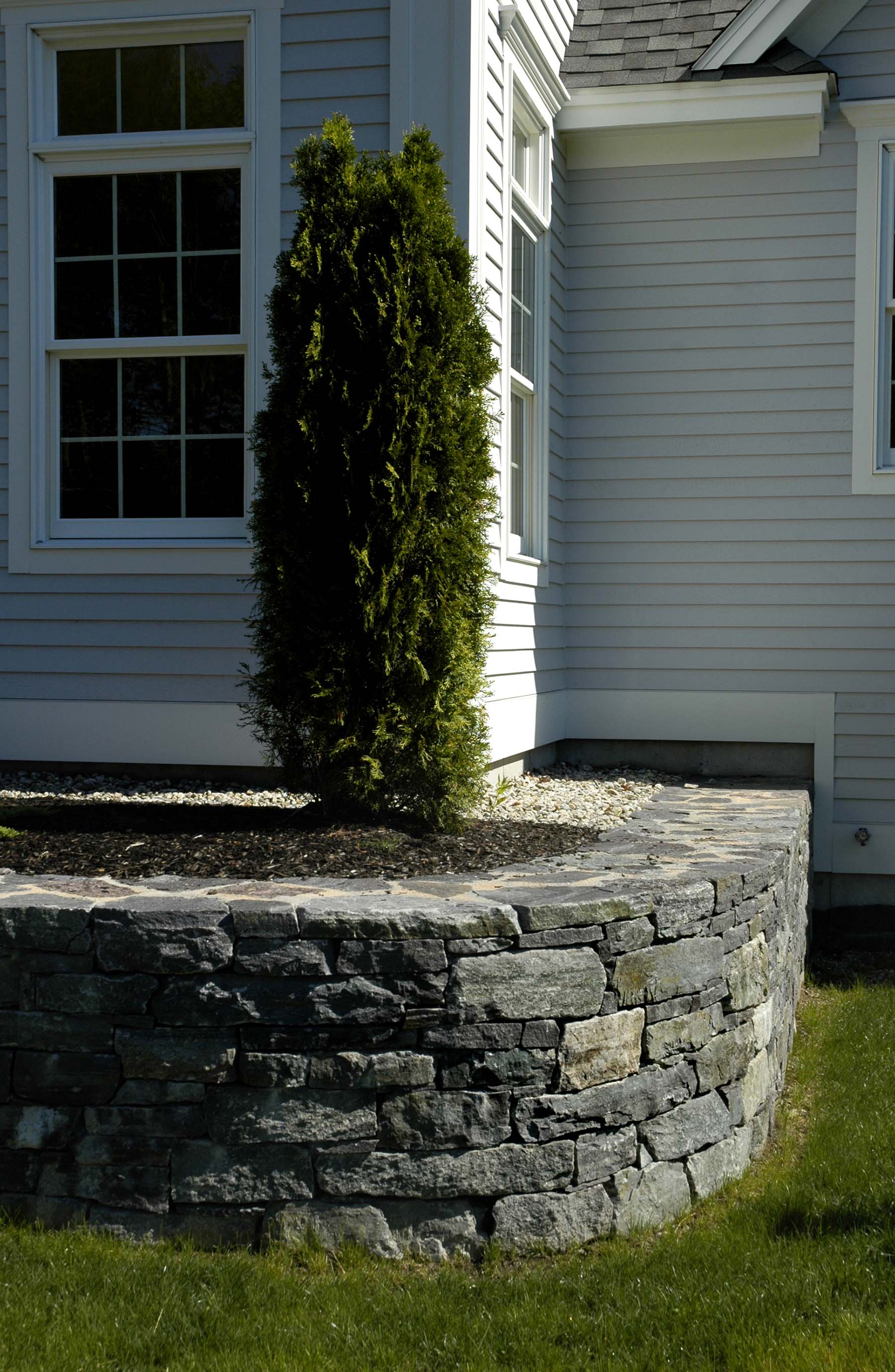 saratoga granite mosaic natural stone retaining wall outside residential home